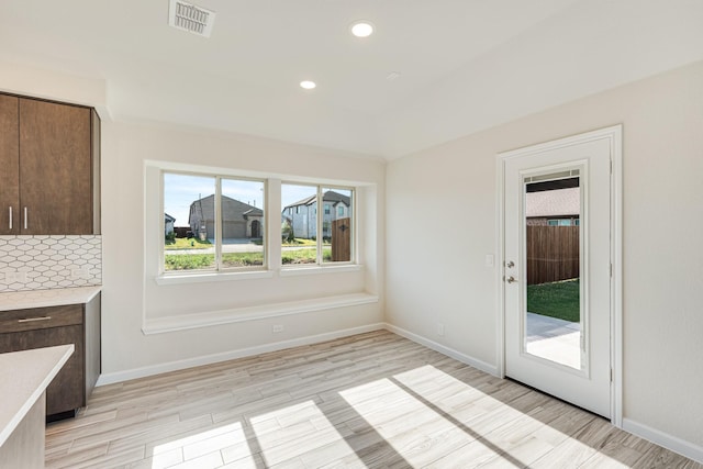 interior space with light wood finished floors, baseboards, visible vents, and recessed lighting