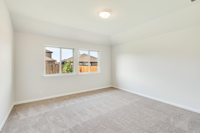 carpeted empty room with lofted ceiling and baseboards