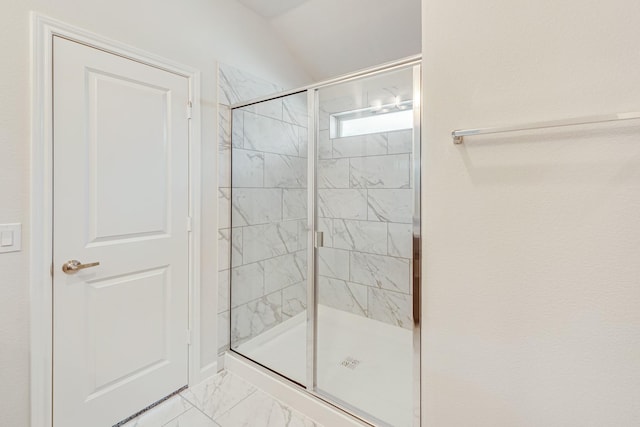 bathroom with marble finish floor and a stall shower