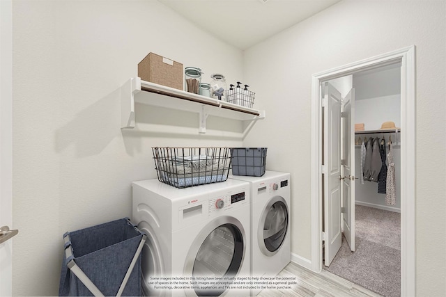 clothes washing area with light carpet and washer and dryer