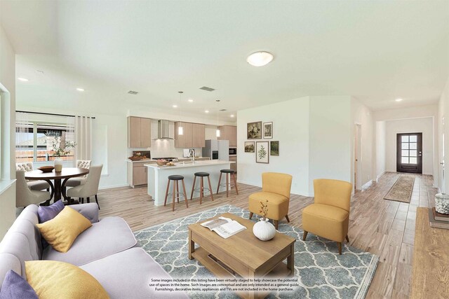 living room featuring a wealth of natural light, light hardwood / wood-style flooring, and sink