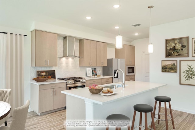 kitchen featuring decorative backsplash, wall chimney exhaust hood, hanging light fixtures, sink, and a center island with sink