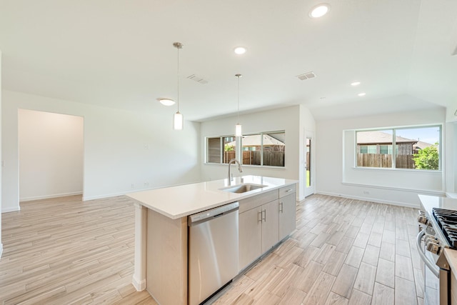 kitchen featuring visible vents, appliances with stainless steel finishes, open floor plan, and a sink