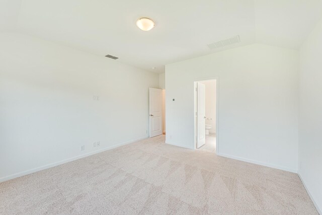 carpeted spare room with vaulted ceiling