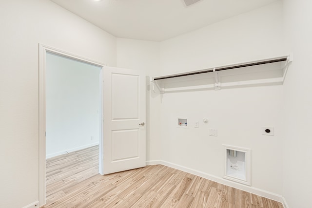 clothes washing area featuring light hardwood / wood-style floors, hookup for a washing machine, electric dryer hookup, and gas dryer hookup