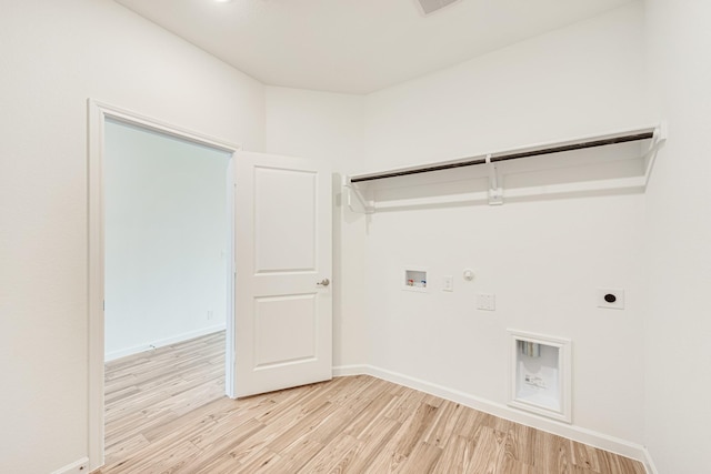 laundry area with washer hookup, hookup for a gas dryer, light wood-style floors, hookup for an electric dryer, and baseboards