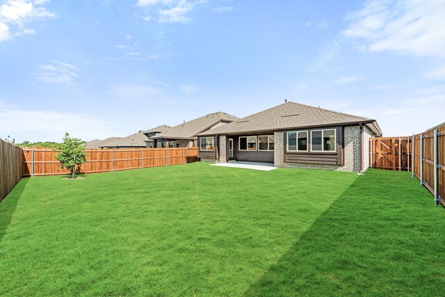 rear view of house featuring a patio area and a yard