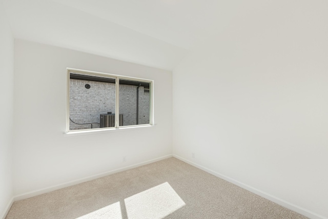 carpeted spare room featuring baseboards