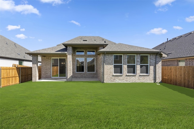 rear view of house with a patio and a yard