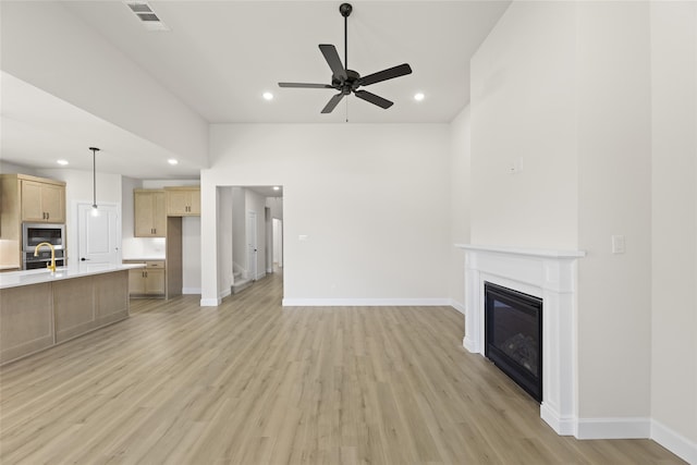 unfurnished living room with ceiling fan and light hardwood / wood-style flooring