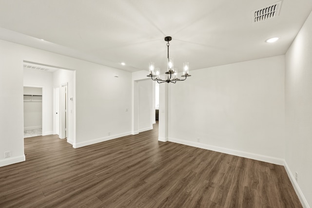 unfurnished dining area with dark wood-type flooring and a notable chandelier