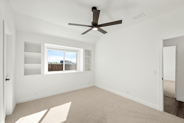 spare room with ceiling fan, built in features, wood-type flooring, and lofted ceiling