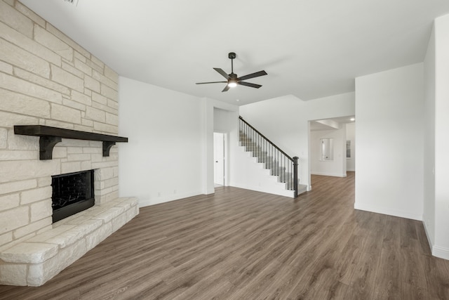 unfurnished living room featuring dark hardwood / wood-style floors, ceiling fan, and a fireplace