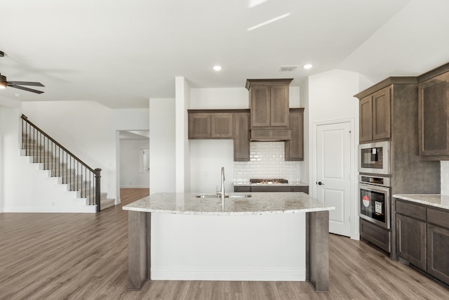 kitchen with sink, appliances with stainless steel finishes, and light hardwood / wood-style flooring