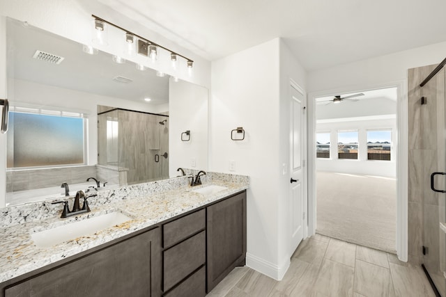 bathroom featuring ceiling fan, vanity, and plus walk in shower