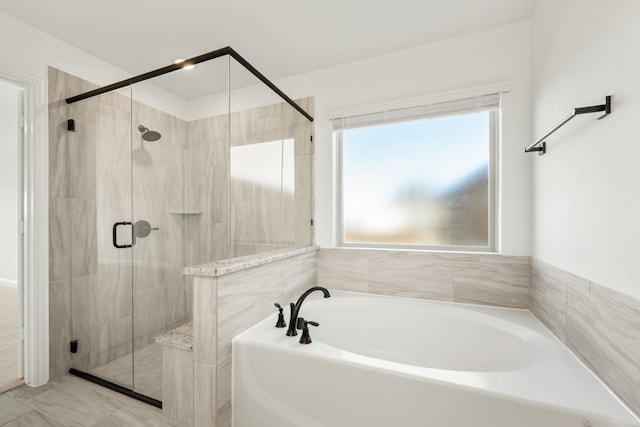 bathroom featuring separate shower and tub