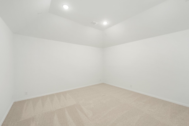 empty room with light carpet and vaulted ceiling