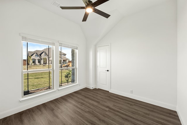 spare room featuring lofted ceiling, a wealth of natural light, ceiling fan, and dark hardwood / wood-style floors