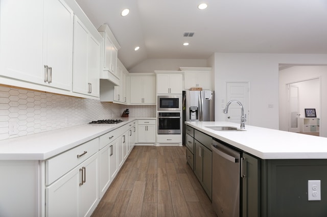 kitchen with sink, stainless steel appliances, decorative backsplash, and white cabinets