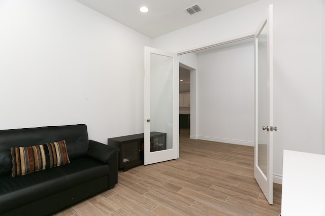 sitting room featuring light hardwood / wood-style floors and french doors