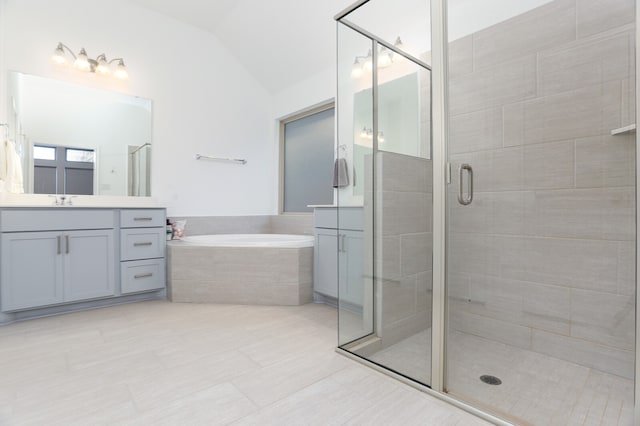 bathroom with lofted ceiling, shower with separate bathtub, vanity, and tile patterned floors