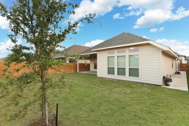 rear view of property featuring a patio area and a yard