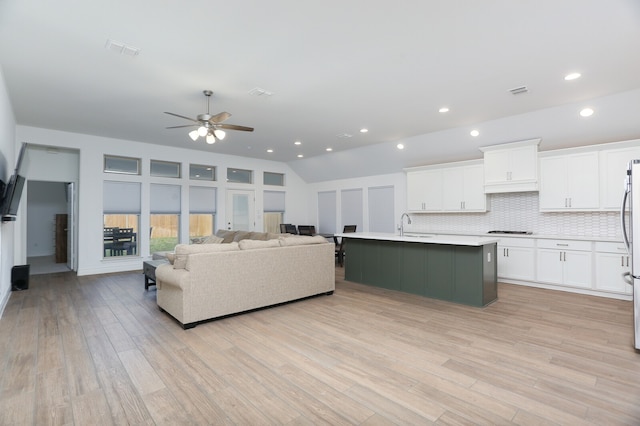 living room featuring ceiling fan, sink, and light wood-type flooring