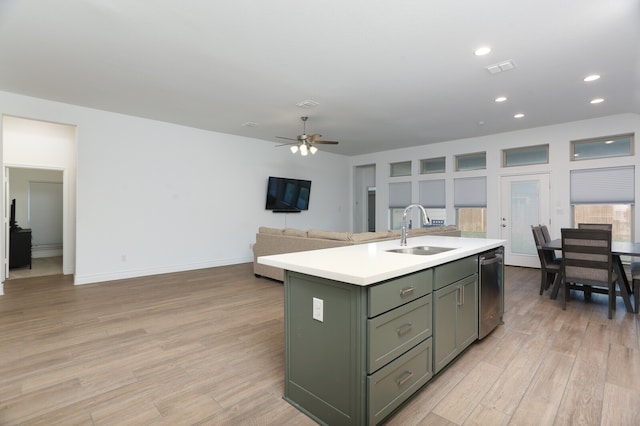 kitchen featuring sink, an island with sink, light hardwood / wood-style floors, stainless steel dishwasher, and ceiling fan