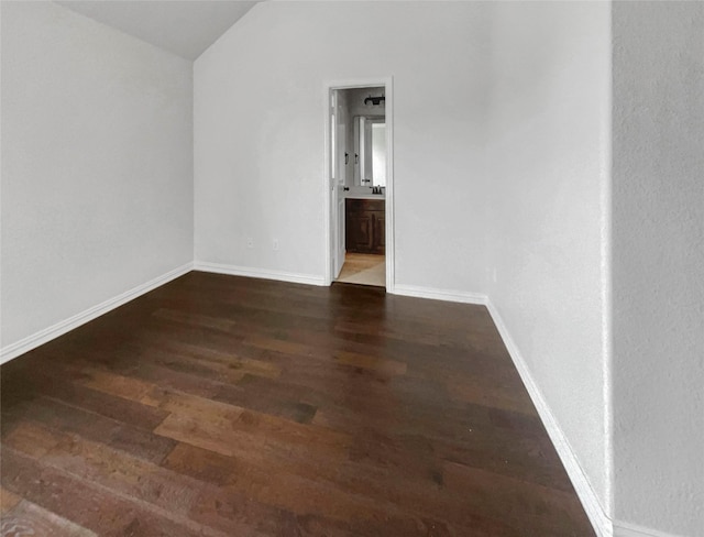 empty room featuring dark hardwood / wood-style floors and vaulted ceiling