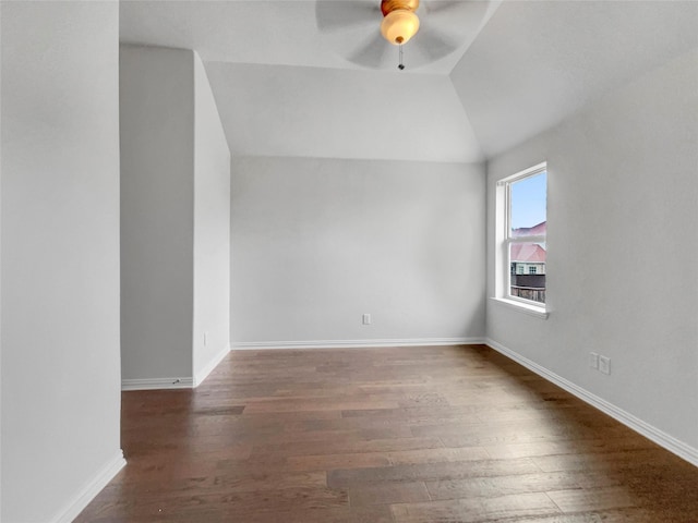 spare room featuring ceiling fan, dark hardwood / wood-style flooring, and vaulted ceiling