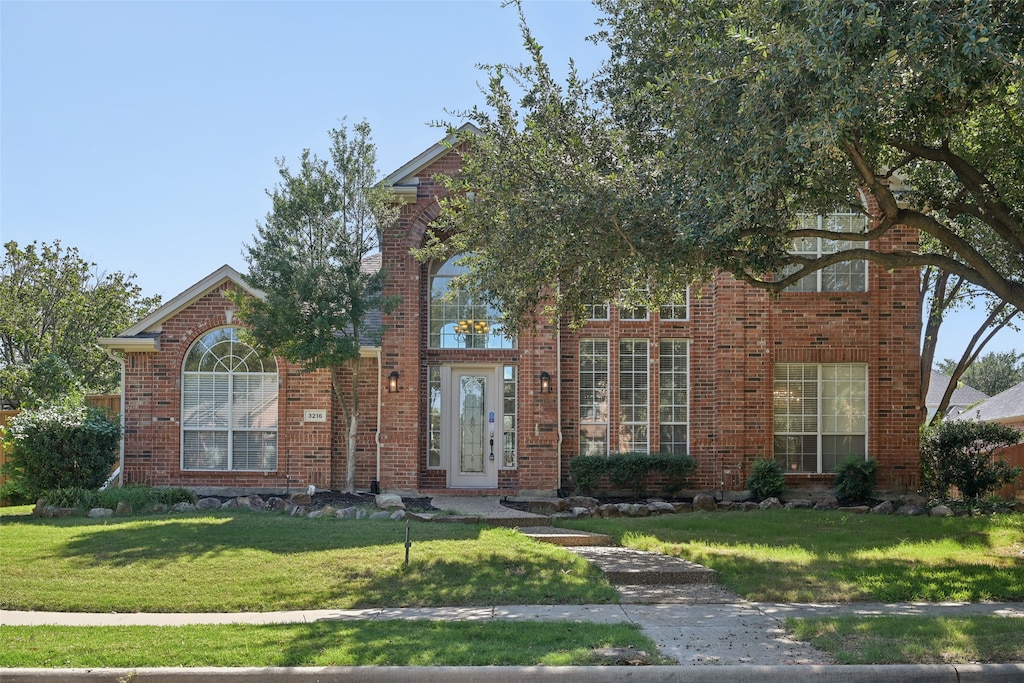 view of front of property featuring a front yard and french doors