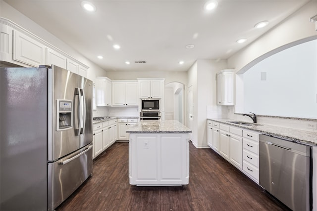 kitchen with sink, dark wood-type flooring, stainless steel appliances, and white cabinets