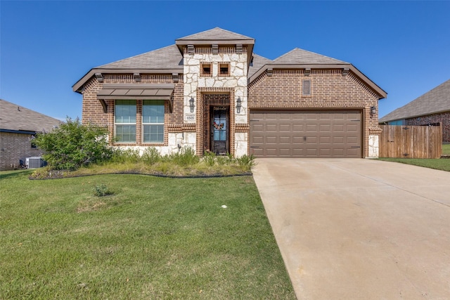 view of front of property featuring cooling unit, a garage, and a front lawn