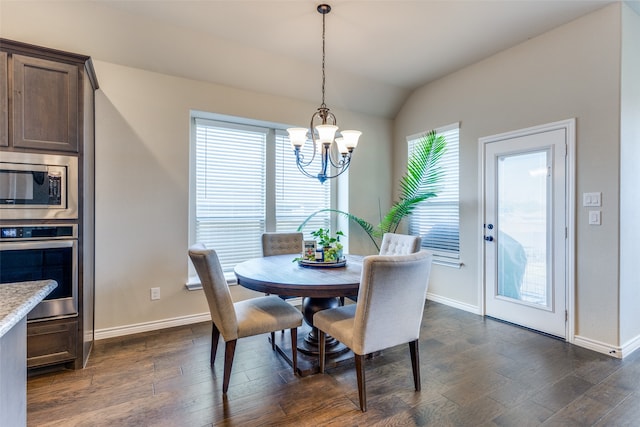 dining area with a notable chandelier, vaulted ceiling, and dark wood-type flooring