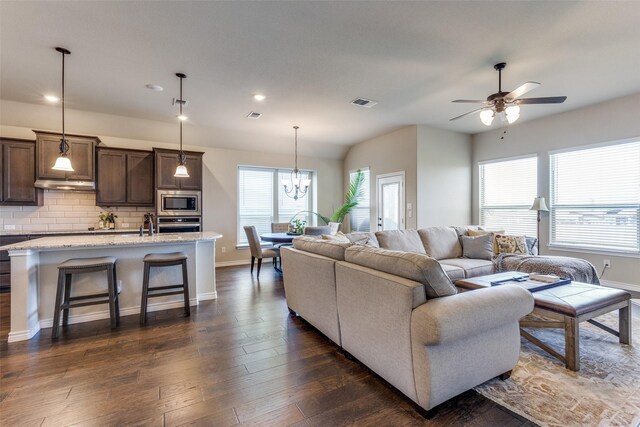 living room with dark wood-type flooring and ceiling fan