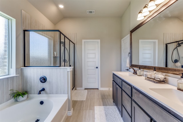 bathroom featuring dual vanity, lofted ceiling, shower with separate bathtub, and tile floors