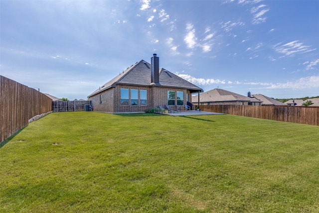 back of house with a lawn and a patio area