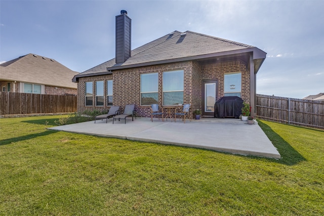 rear view of house with a lawn and a patio