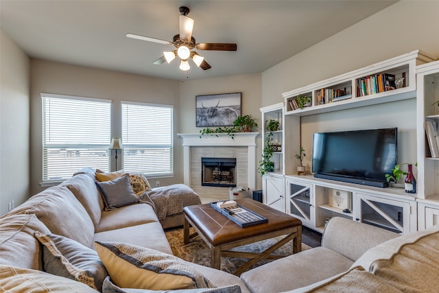 living room with a tiled fireplace and ceiling fan