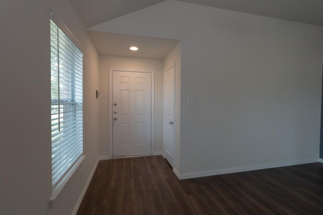 hall with vaulted ceiling and dark hardwood / wood-style flooring