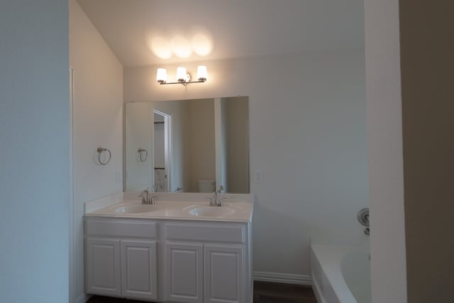 bathroom with a tub to relax in and vanity