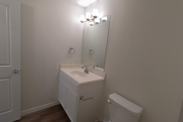 bathroom featuring hardwood / wood-style floors, vanity, and toilet