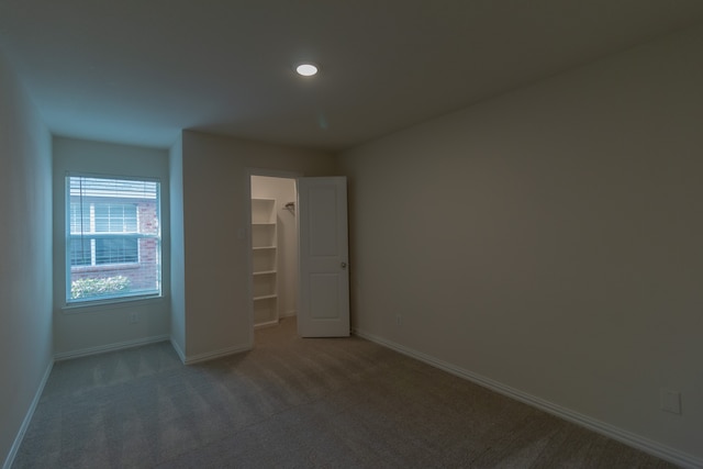 unfurnished bedroom with carpet, a closet, and a walk in closet