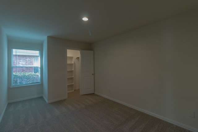 unfurnished bedroom with a closet, carpet, and a walk in closet