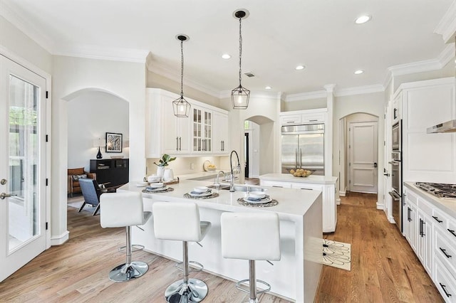 kitchen featuring white cabinets, a breakfast bar, light wood-type flooring, and stainless steel appliances