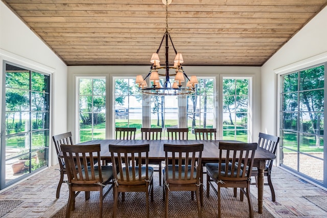 dining room with a healthy amount of sunlight, vaulted ceiling, and an inviting chandelier