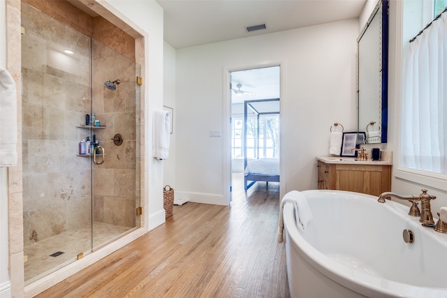 bathroom featuring ceiling fan, vanity, hardwood / wood-style flooring, and plus walk in shower