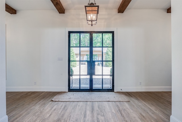 doorway featuring beamed ceiling, wood-type flooring, a chandelier, and french doors