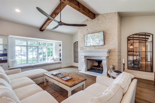 living room featuring ceiling fan, dark hardwood / wood-style flooring, a fireplace, and lofted ceiling with beams