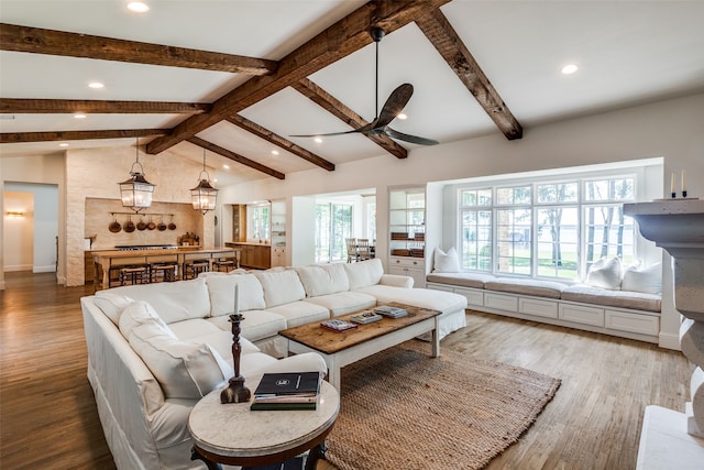 living room featuring lofted ceiling with beams, ceiling fan, and light hardwood / wood-style flooring